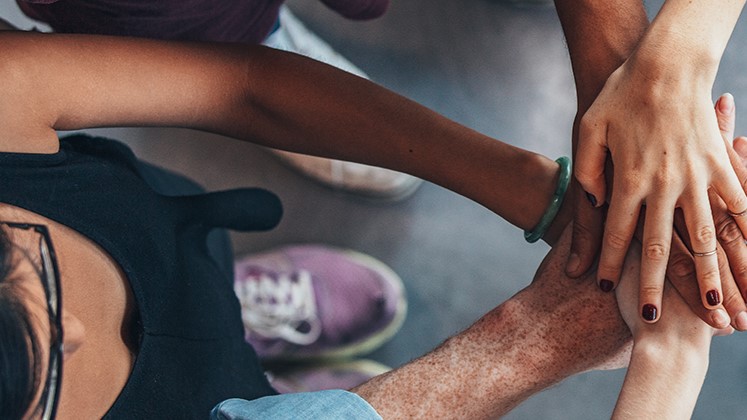 A group of young people lock hands in solidarity