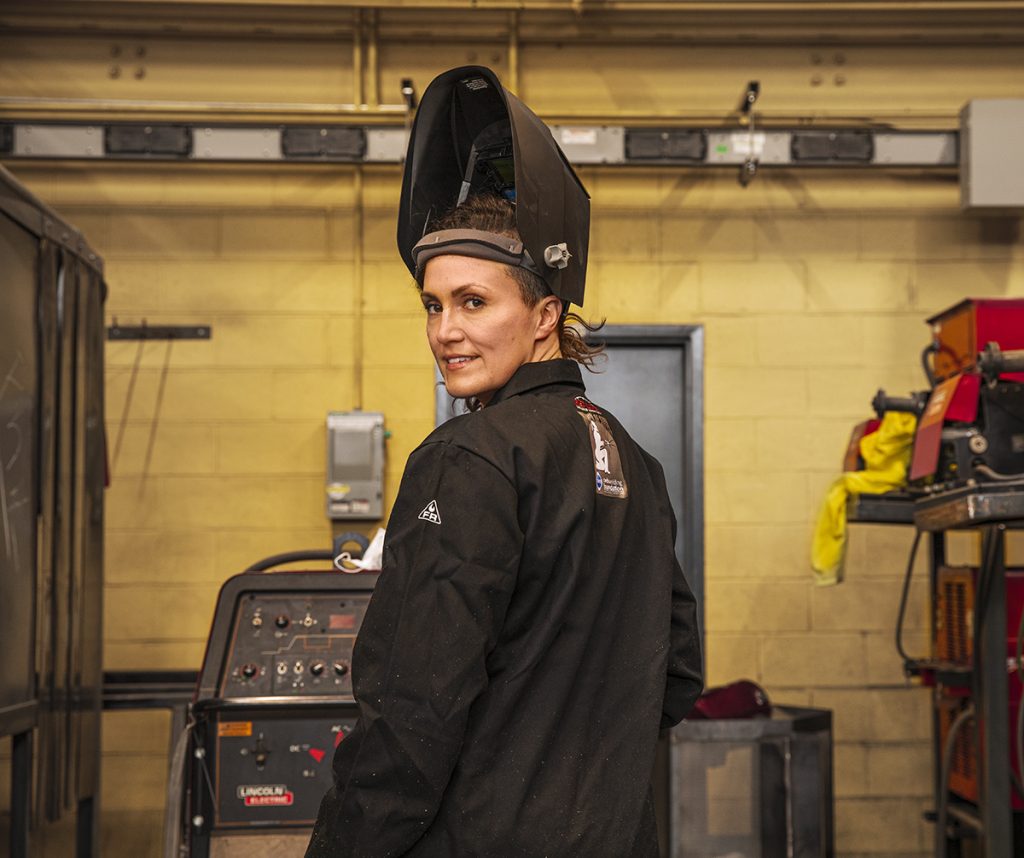 A woman sports a welding mask in a UFV welding shop