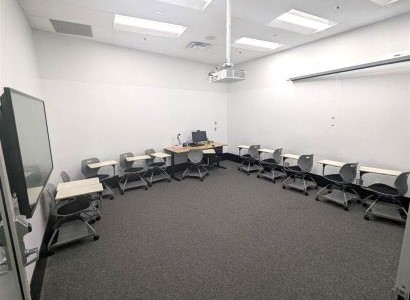 G113 showing a bright white room with no windows, desks, and a projector