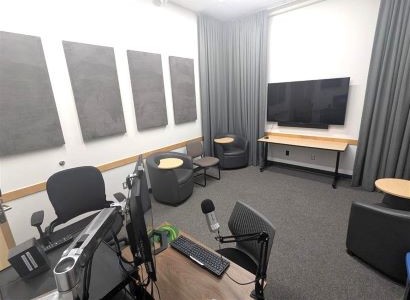 Video room with TV, sound panels on walls, computer, and mic